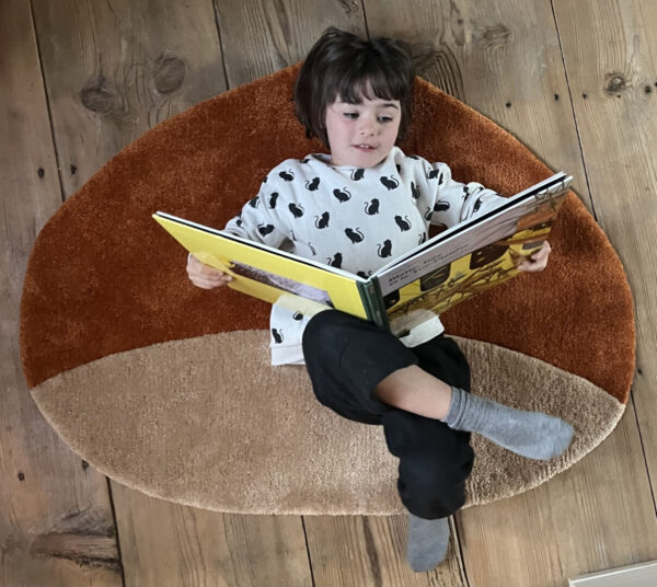 Girl reading on Castagnona tufted rug